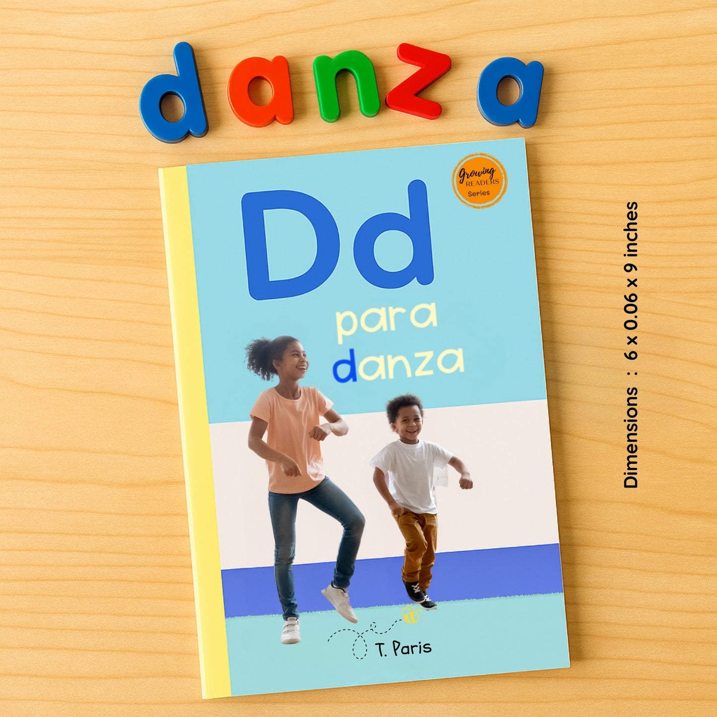 Book titled 'Dd para danza' with colorful letters spelling 'danza' above it on a wooden surface.